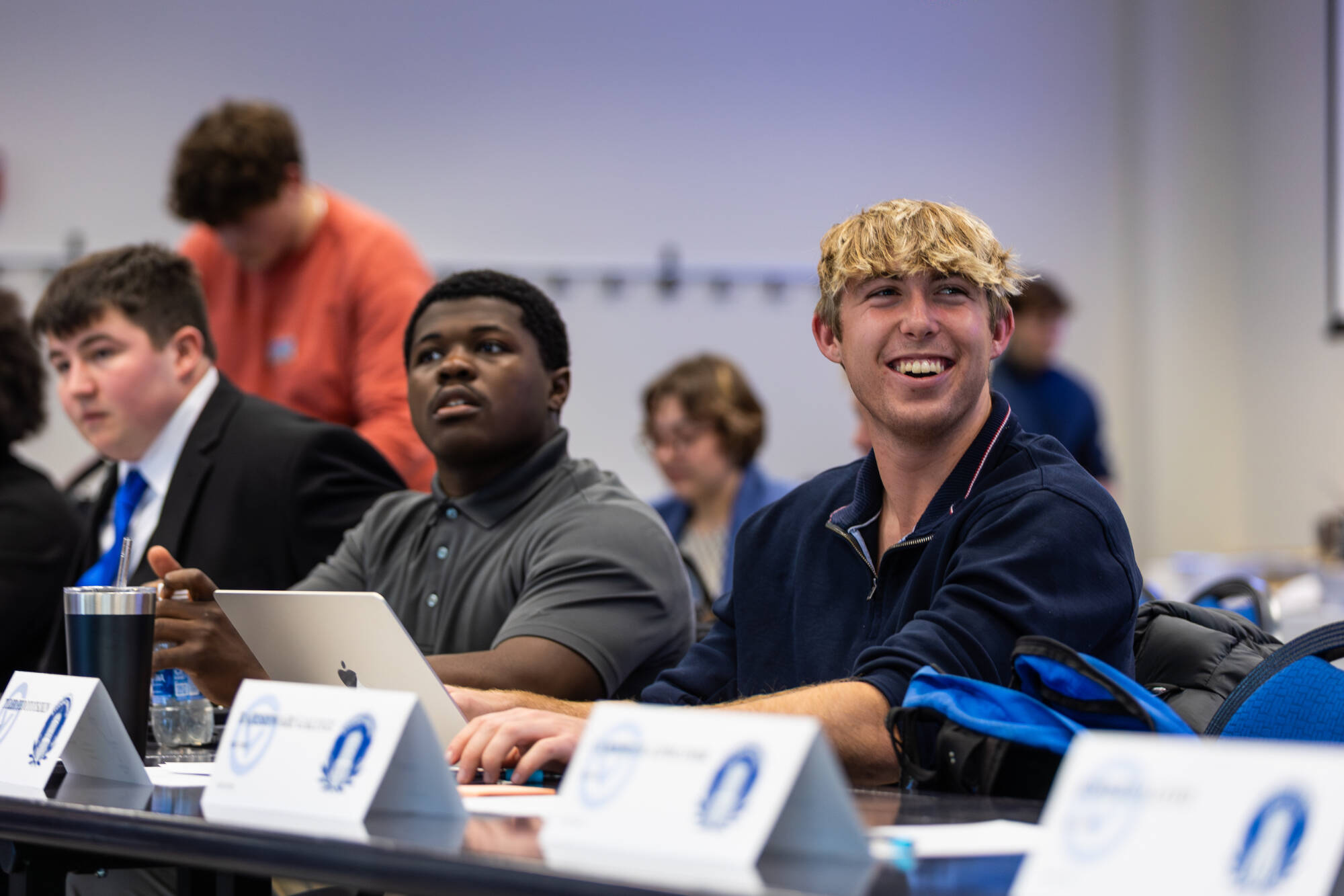 Two senators smiling at a General Assembly meeting.